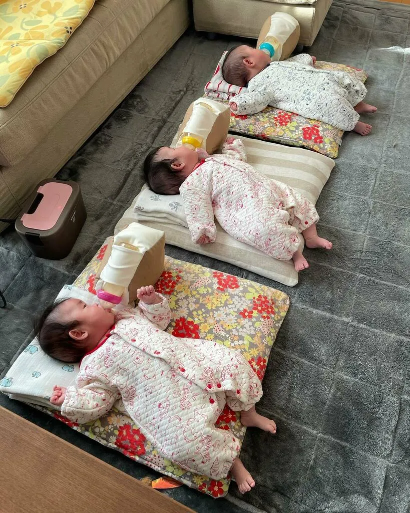 横一列に寝ながらミルクを飲む三つ子