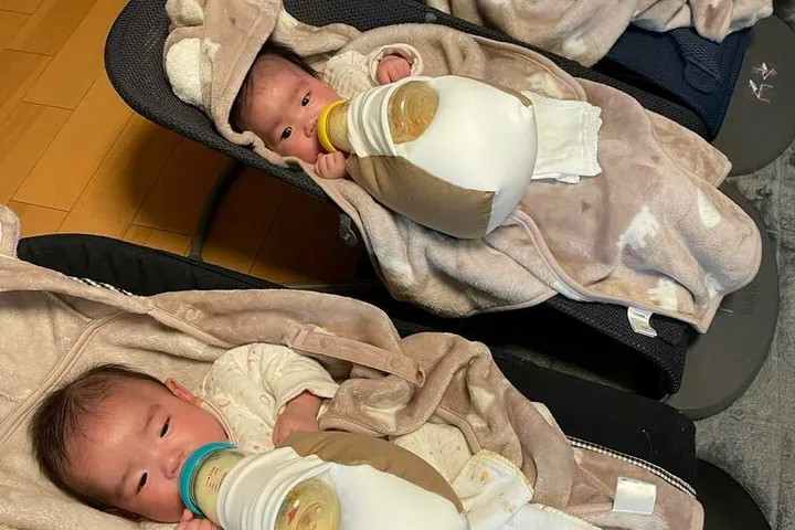 並んで寝ながら同時にミルクを飲む三つ子