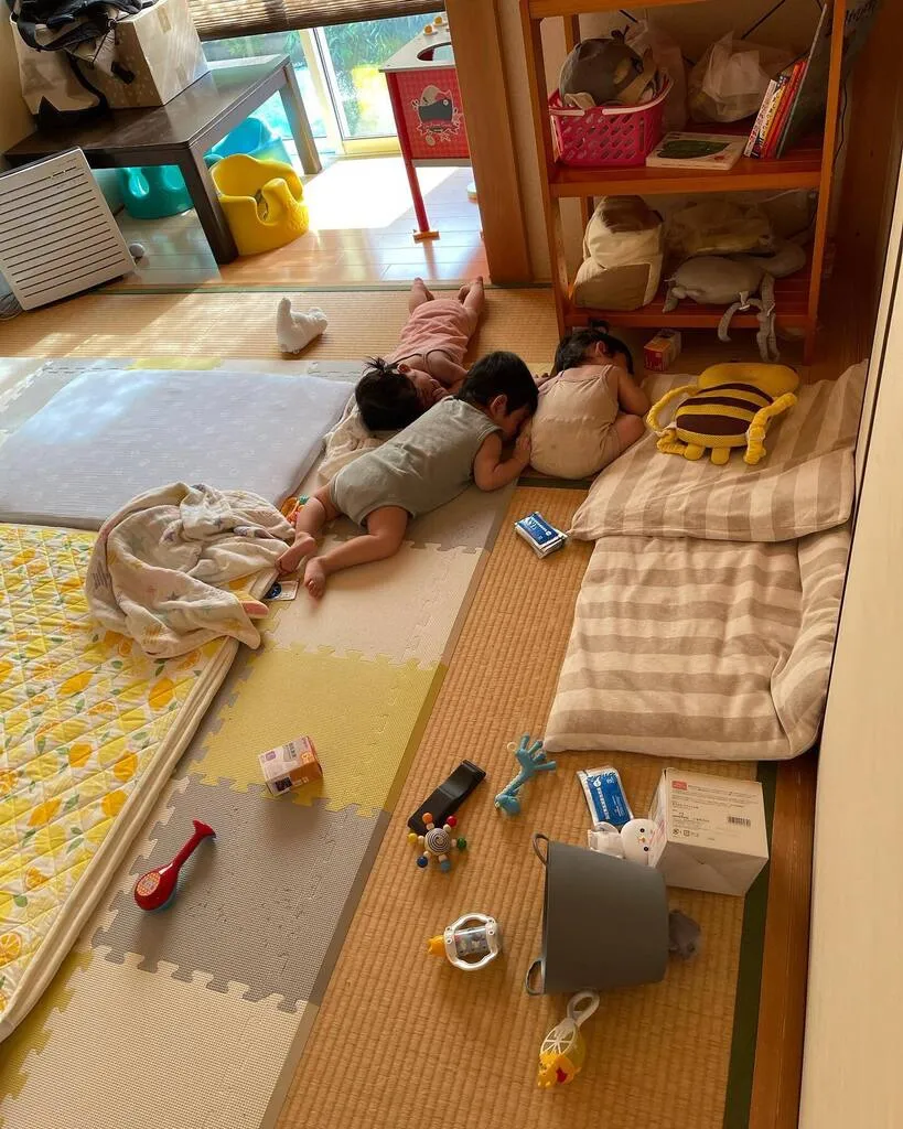 部屋の端で体を寄せ合って眠る三つ子